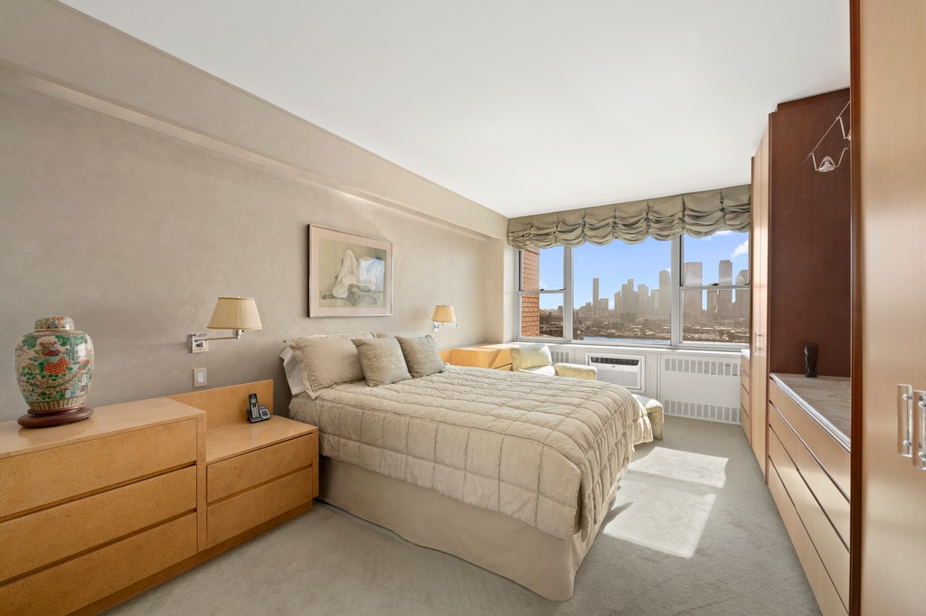 25 Sutton Place South, Unit 18M Manhattan, NY 10022 - Photo 6 of 11 a bedroom with a bed and a window