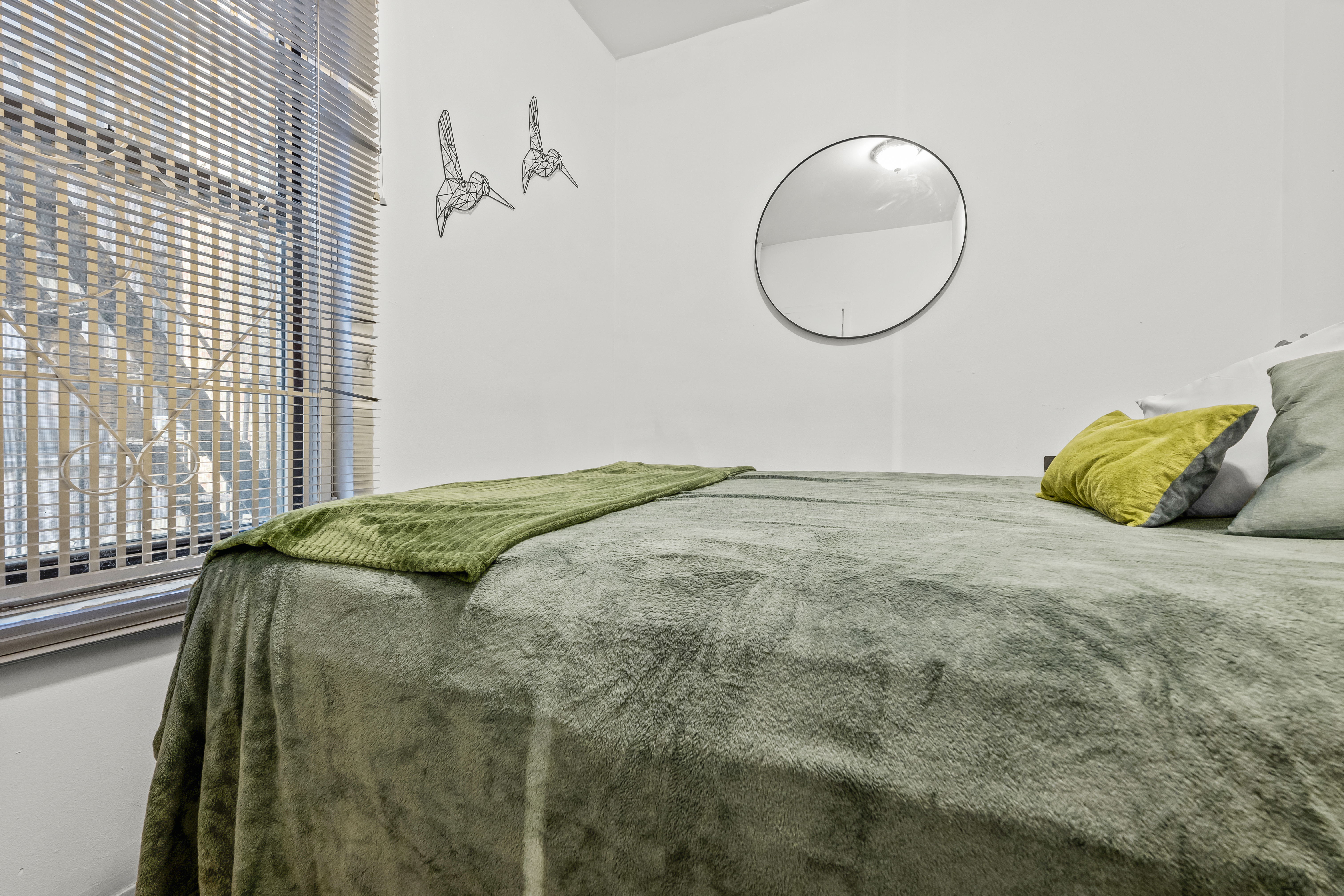 204 West 10th Street, Unit 7A Manhattan, NY 10014 - Photo 12 of 17 a bed sitting in a bedroom next to a window and a mirror