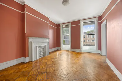 a view of an empty room with window and fire place