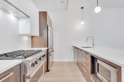 a kitchen with stainless steel appliances granite countertop a sink stove and cabinets