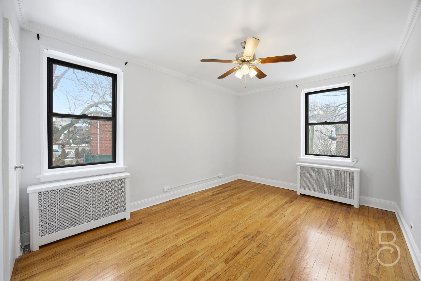78-15 19th Drive, Unit B2 Queens, NY 11370 - Photo 14 of 17 a view of an empty room with wooden floor and a window