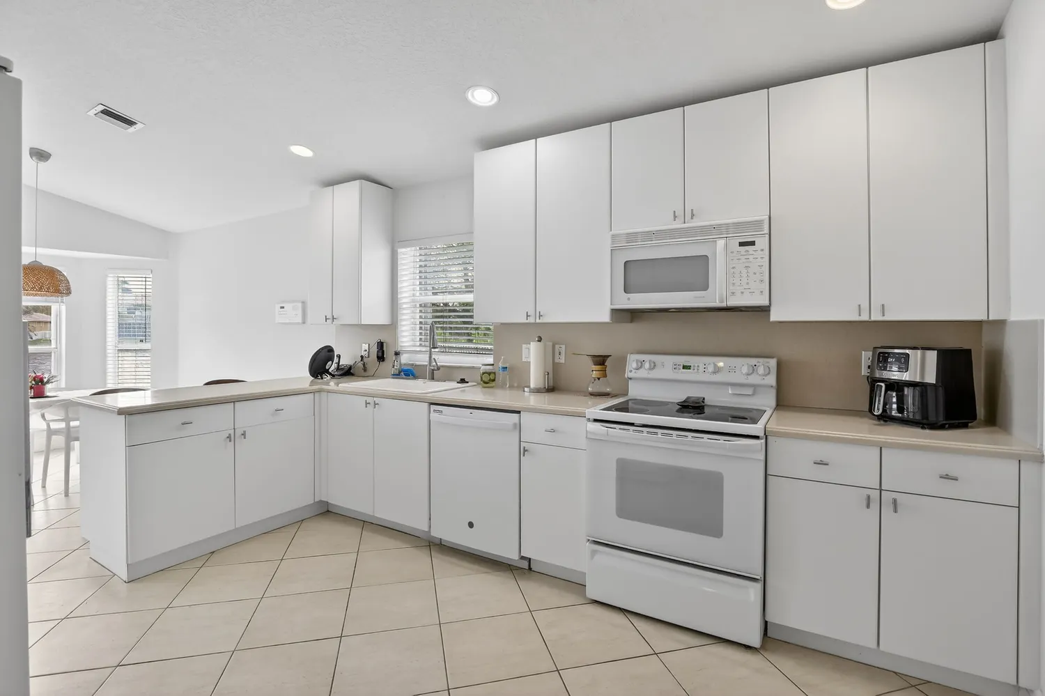 a kitchen with white cabinets appliances and a sink