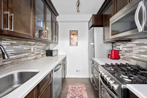 a kitchen with stainless steel appliances granite countertop a sink and a stove