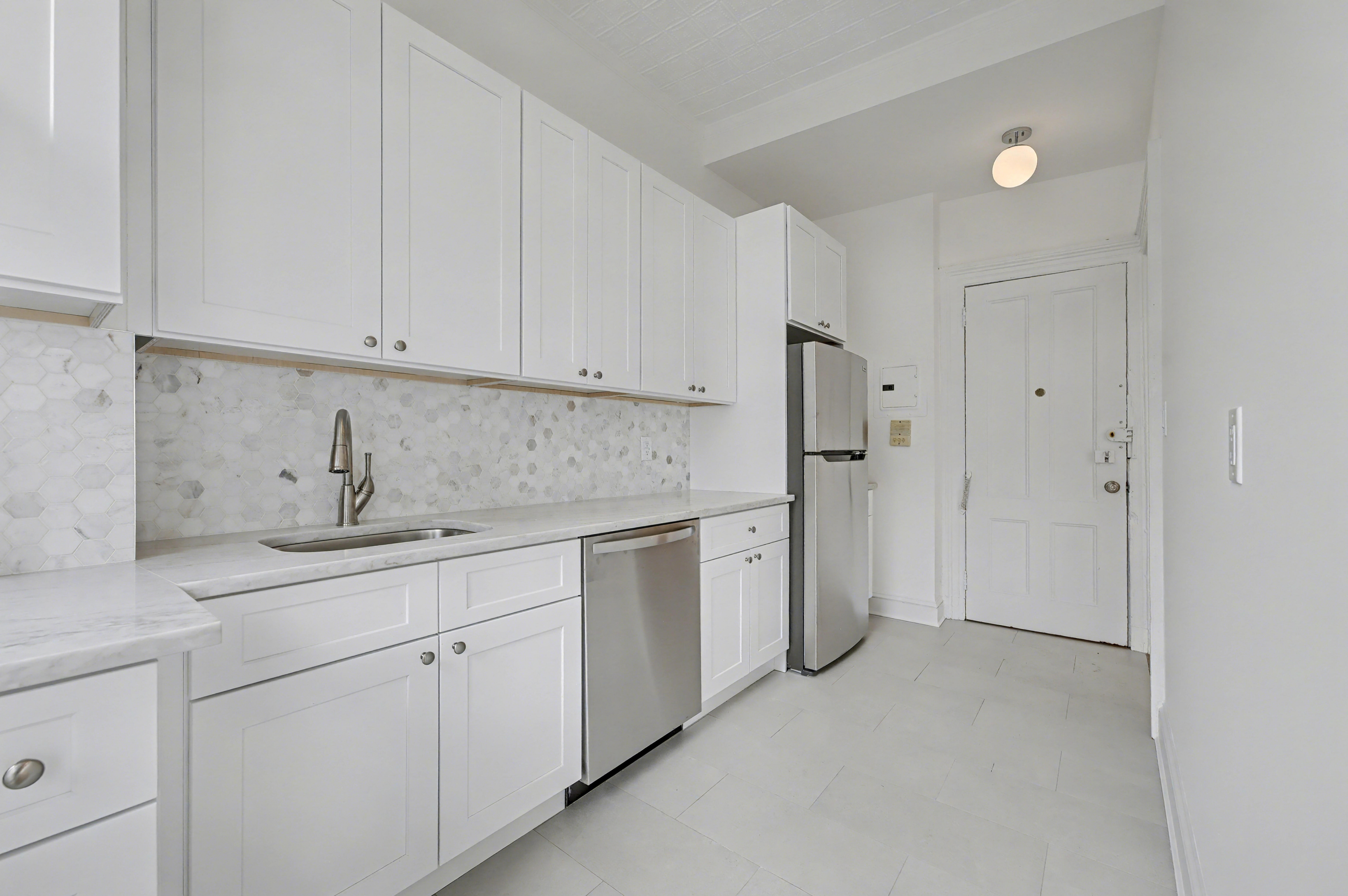 261 Clinton Street, Unit 3 Brooklyn, NY 11201 - Photo 3 of 12 a kitchen with stainless steel appliances granite countertop white cabinets and sink