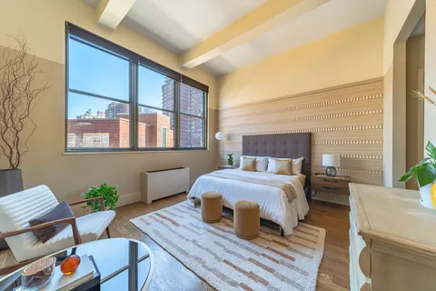 a bedroom with a bed table and chair