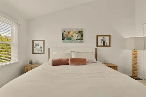 a bedroom with a large bed and a window