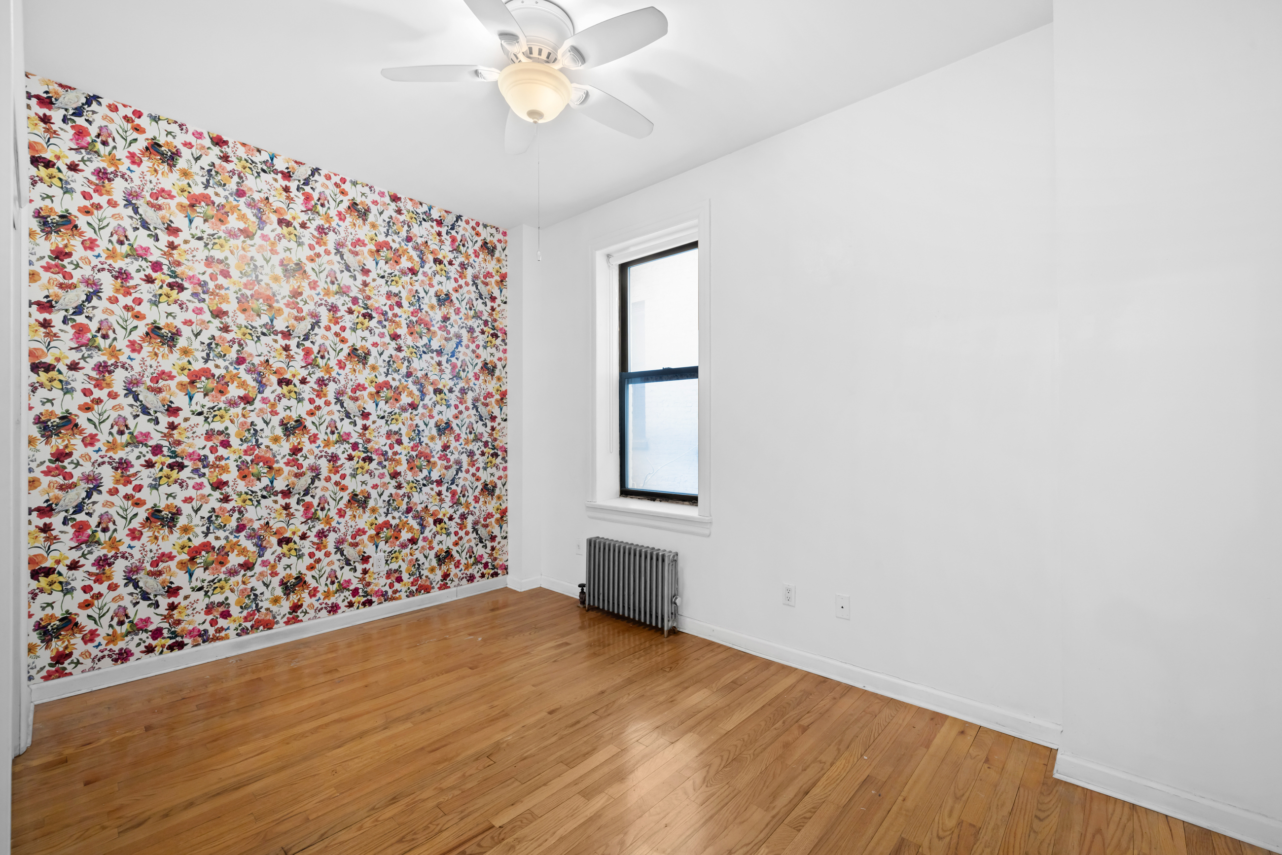 469 West 166th Street, Unit 2C Manhattan, NY 10032 - Photo 6 of 13 a view of empty room with wooden floor and fan