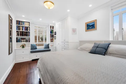 a spacious bedroom with a bed and a book shelf