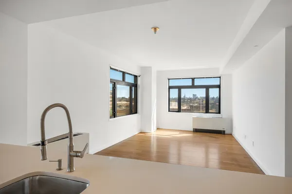 a view of a room that has a window and wooden floor