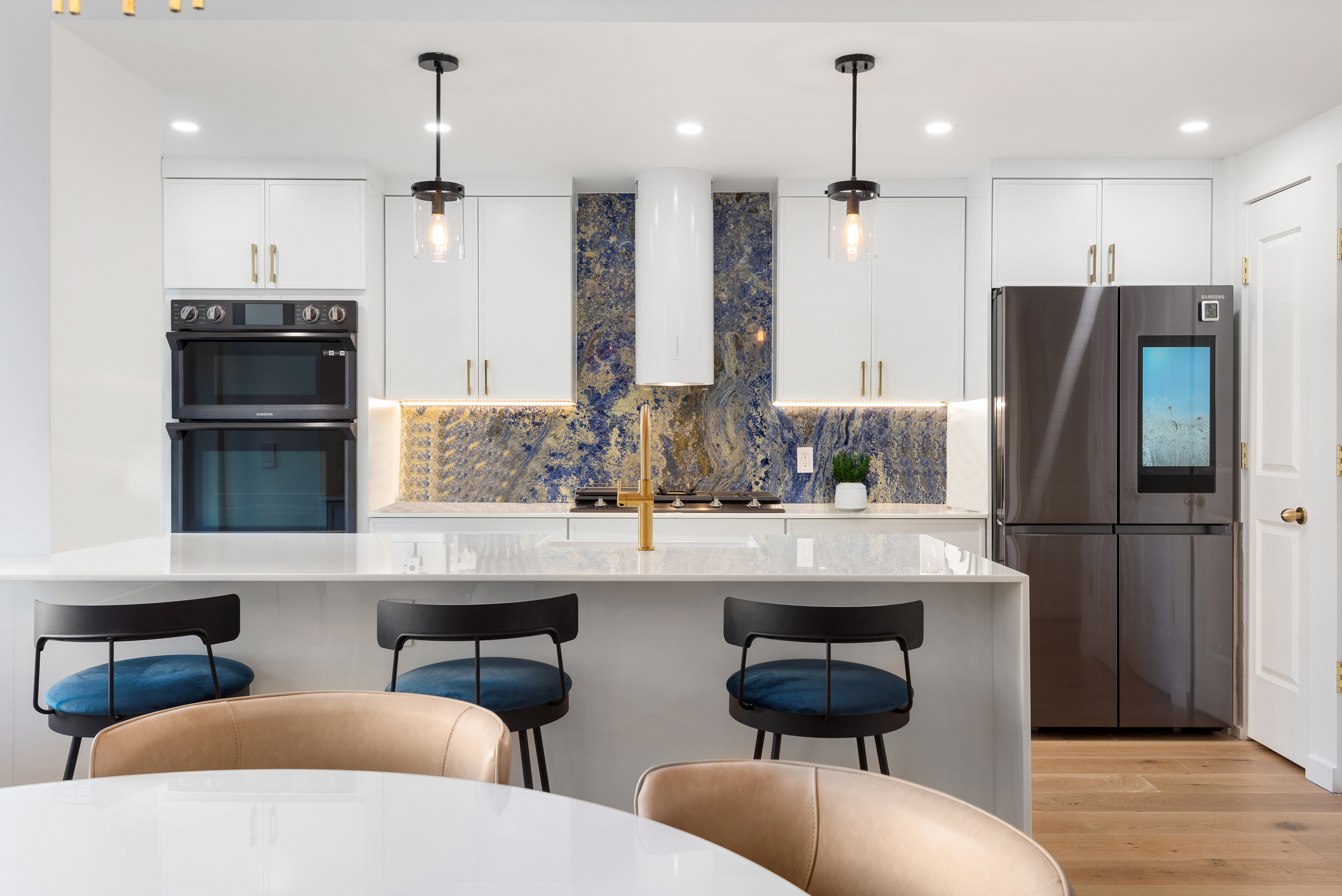 30 East 65th Street, Unit 6B Manhattan, NY 10065 - Photo 5 of 14 a kitchen with stainless steel appliances a refrigerator a sink dishwasher a dining table and chairs with wooden floor