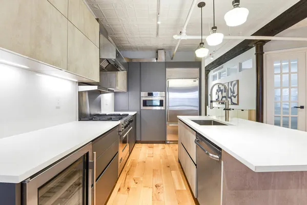a large kitchen with kitchen island a large counter space a sink and appliances