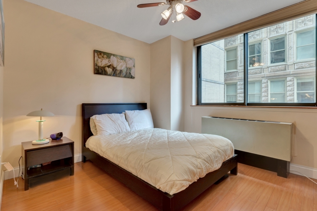 280 Park Avenue South, Unit 4D Manhattan, NY 10010 - Photo 4 of 13 a bedroom with a bed and a chandelier