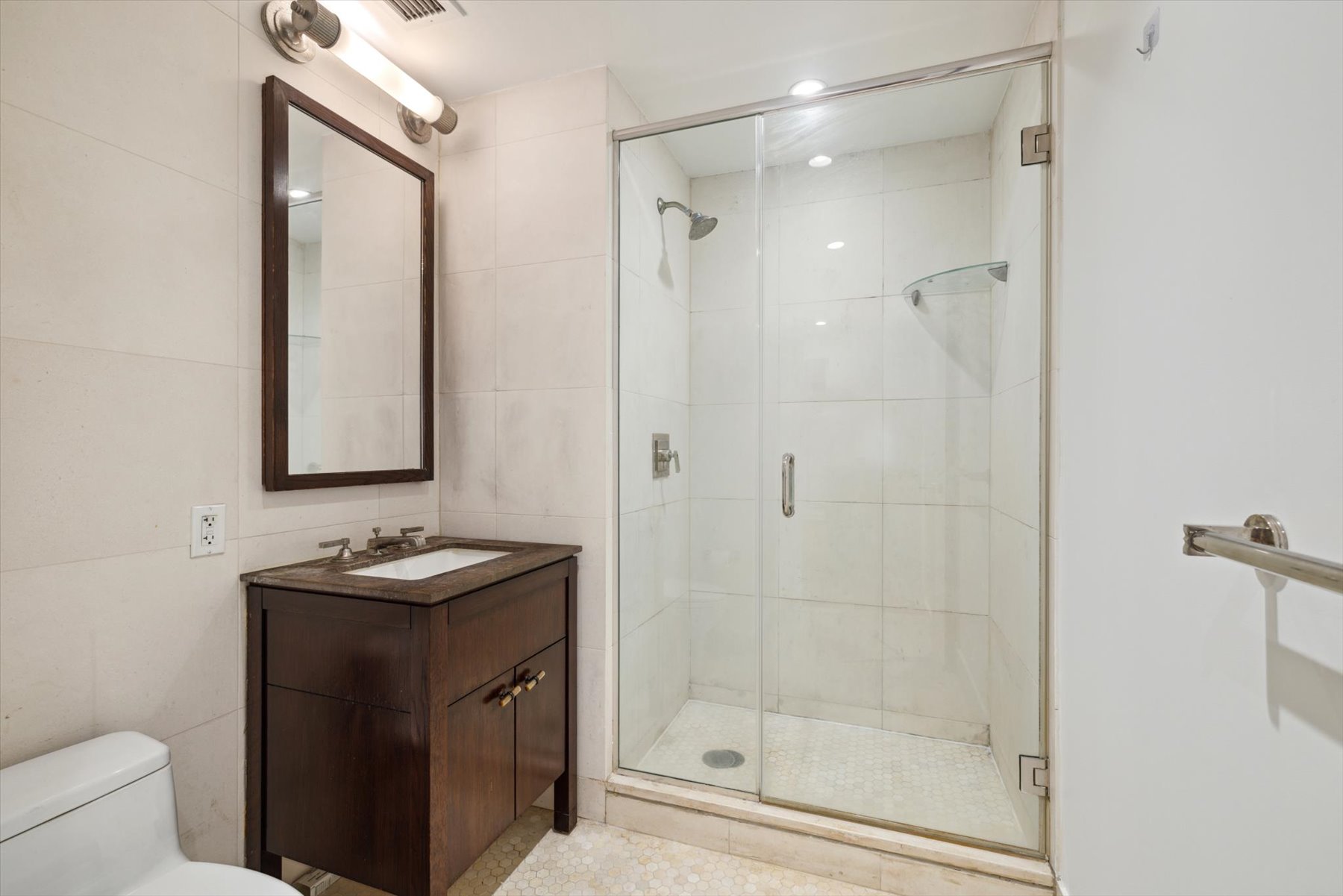 80 Riverside Boulevard, Unit 4Y Manhattan, NY 10069 - Photo 6 of 8 a bathroom with a shower sink vanity and mirror