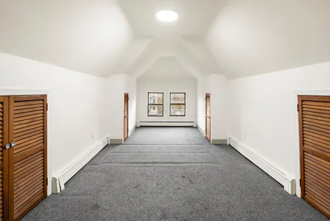 an empty room with windows and cabinet