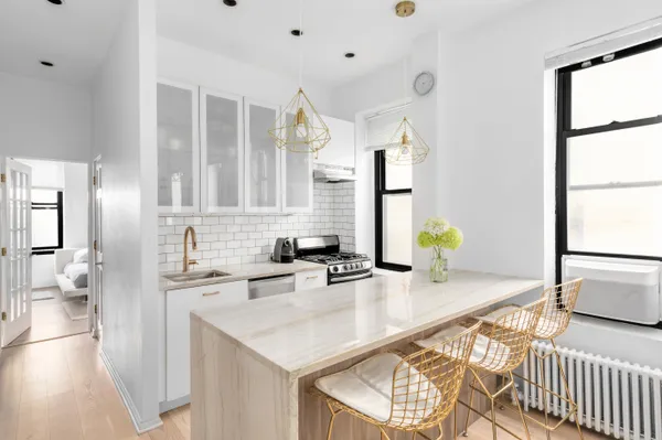 a kitchen with granite countertop a sink a stove and cabinets