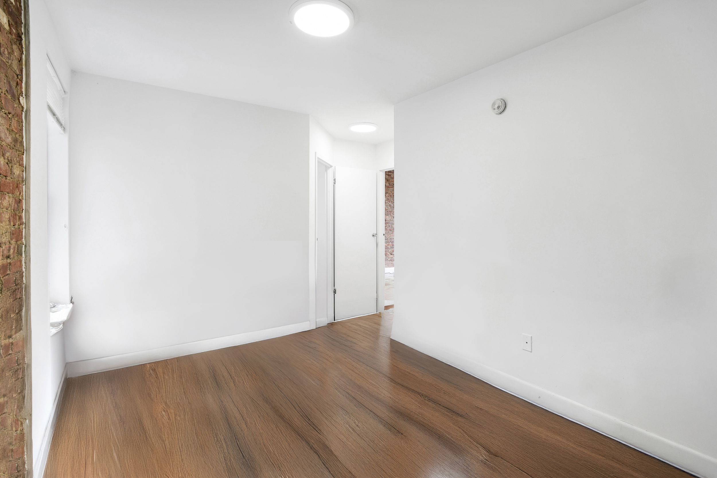 214 East 82nd Street, Unit 27 Manhattan, NY 10028 - Photo 3 of 6 a view of an empty room with wooden floor