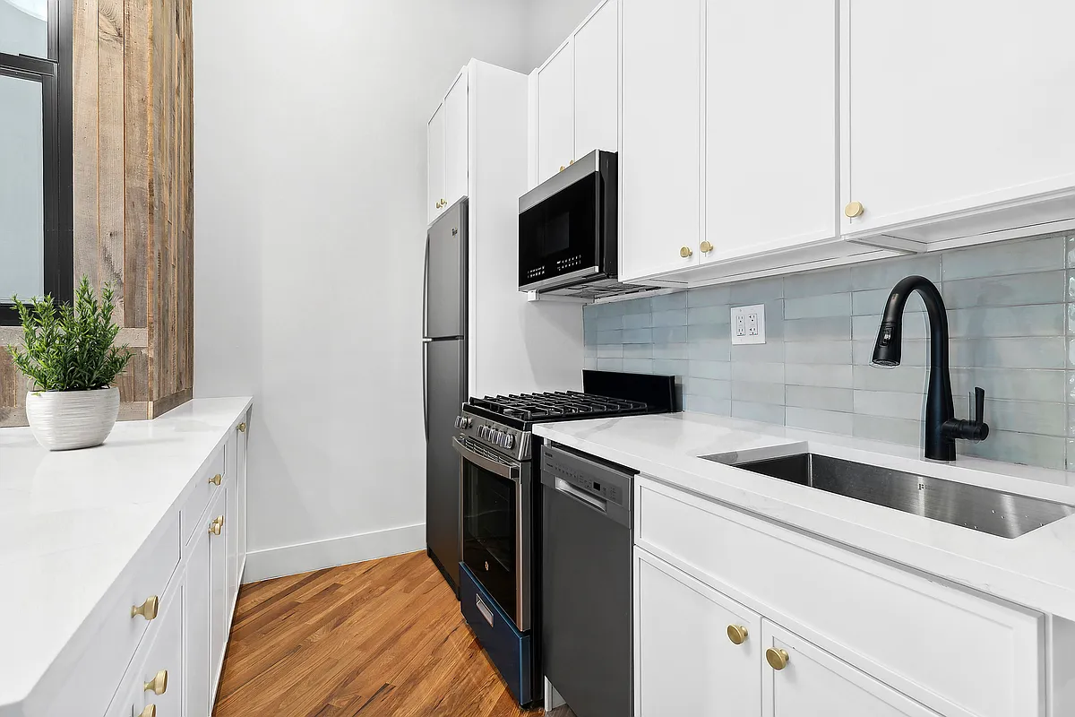866 Bushwick Avenue, Unit 1 Brooklyn, NY 11221 - Photo 5 of 13 a kitchen with stainless steel appliances granite countertop a sink and a microwave