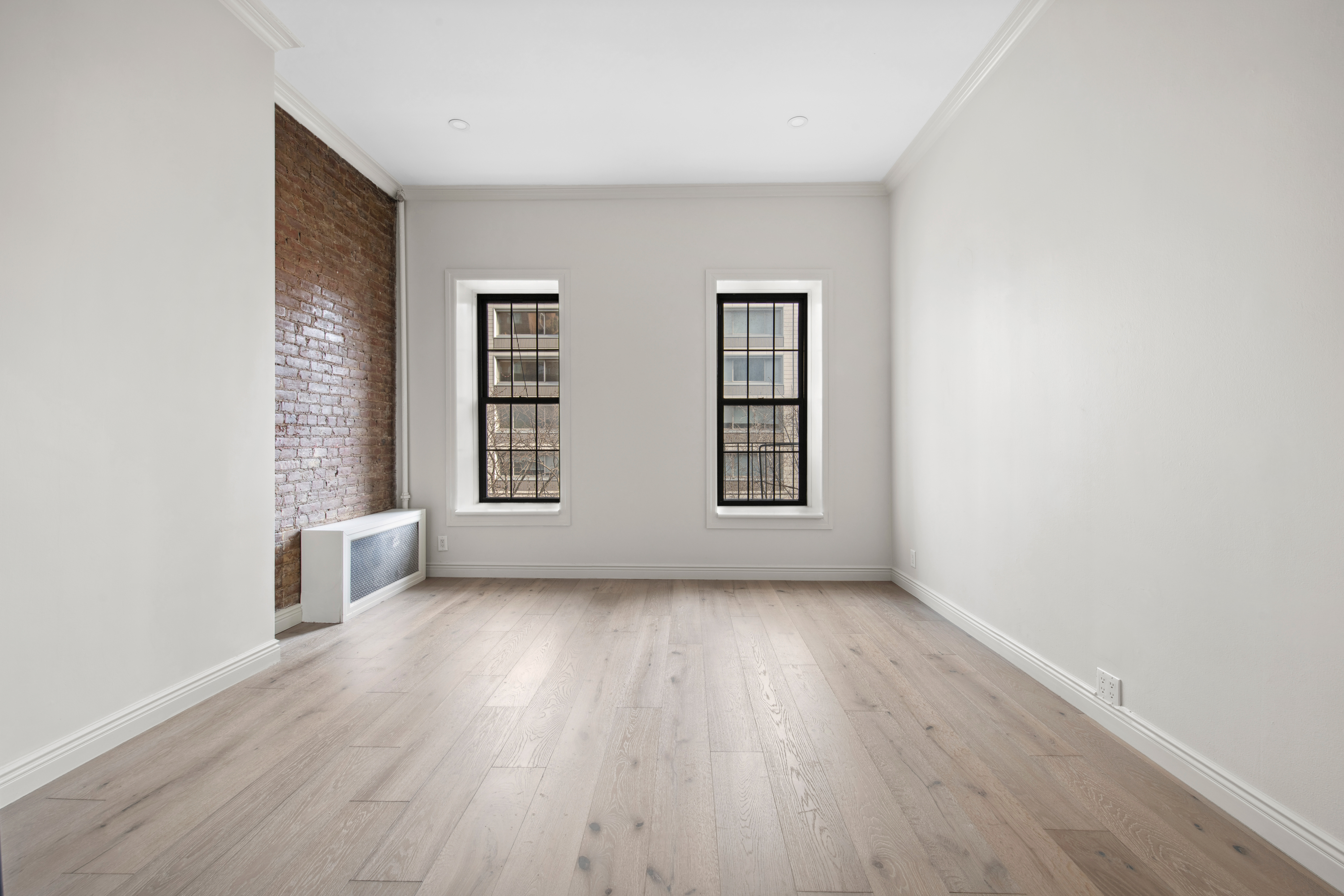 212 East 70th Street, Unit 4B Manhattan, NY 10021 - Photo 4 of 16 an empty room with wooden floor and windows