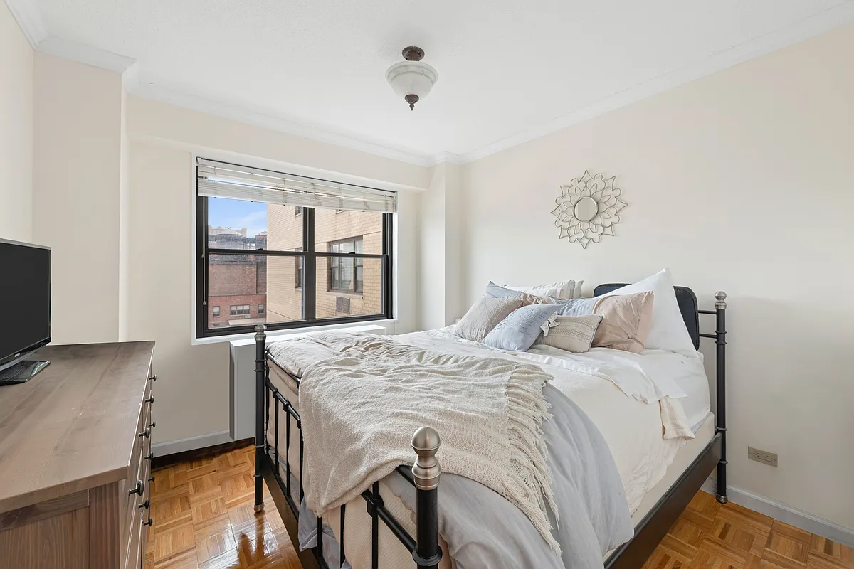345 East 80th Street, Unit 22L Manhattan, NY 10075 - Photo 3 of 7 a bed sitting in a bedroom next to a window