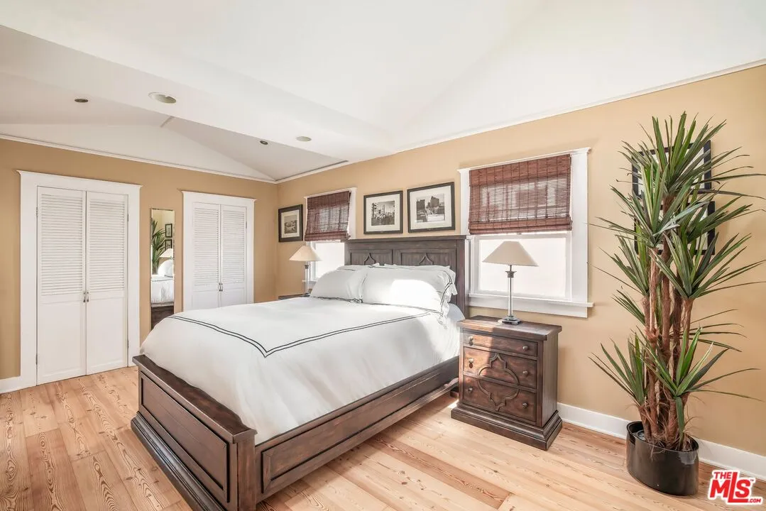 a bedroom with a large bed and a potted plant