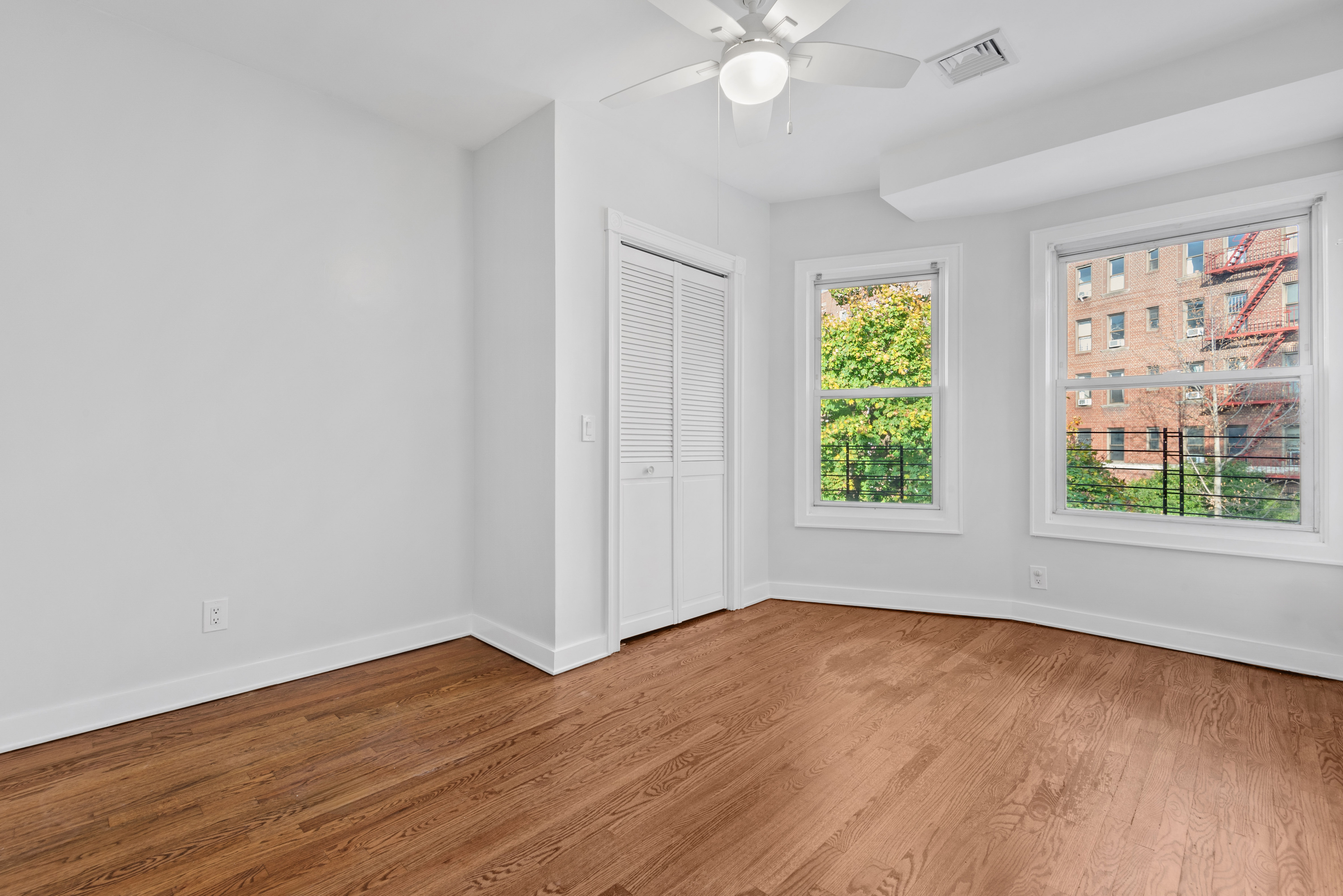 1617 Dorchester Road, Unit 2 Brooklyn, NY 11226 - Photo 4 of 6 a view of an empty room with wooden floor and a window