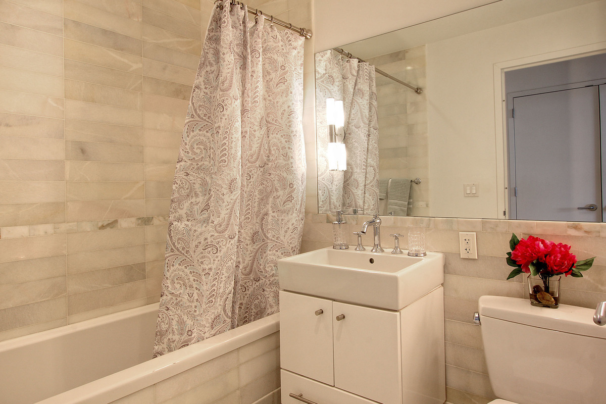 635 West 42nd Street, Unit 10A Manhattan, NY 10036 - Photo 4 of 7 a bathroom with a sink and a mirror