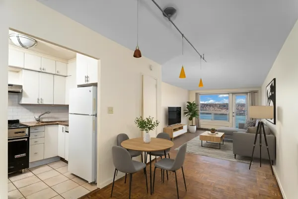 a kitchen with stainless steel appliances a dining table chairs and a refrigerator
