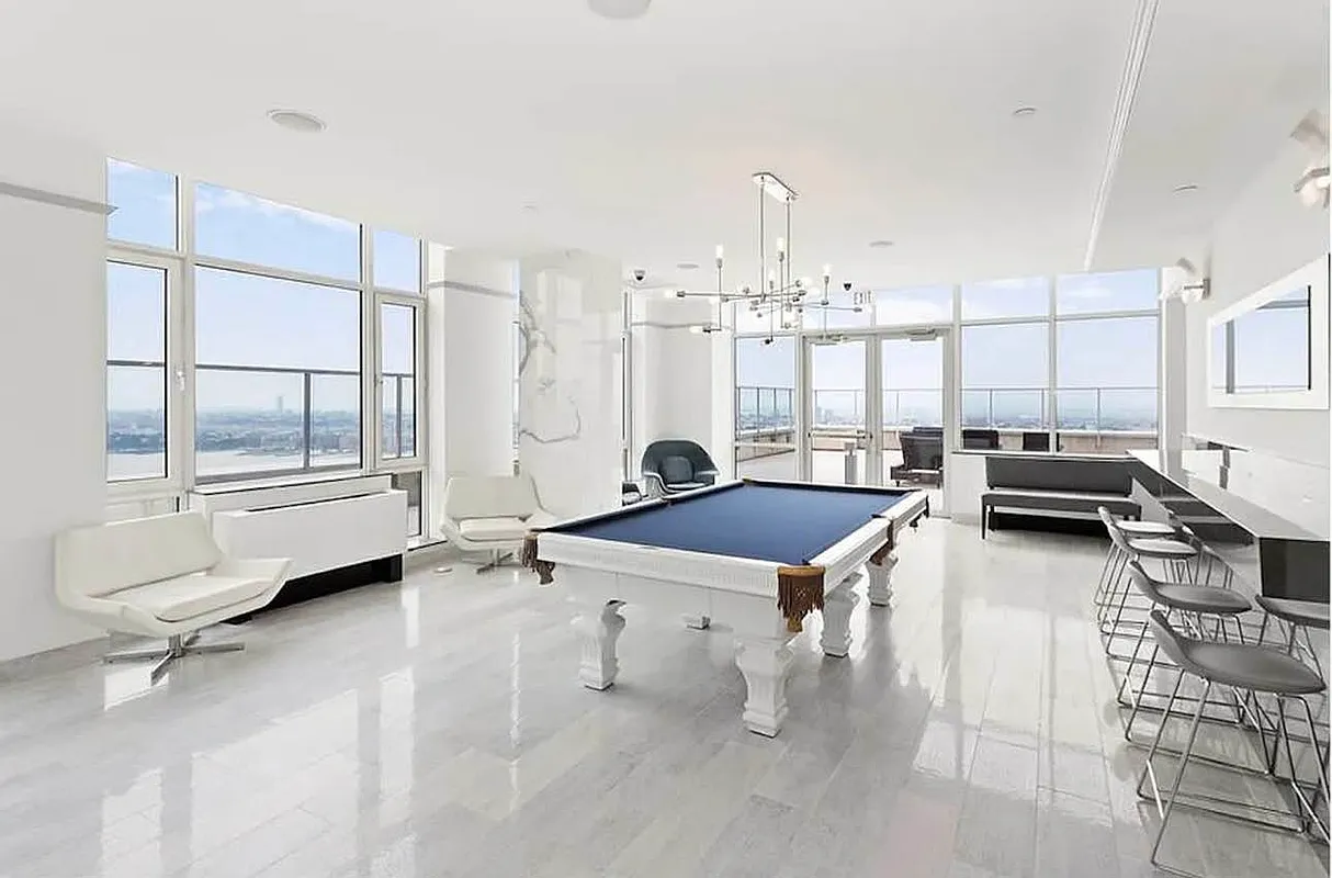 635 West 42nd Street, Unit 10C Manhattan, NY 10036 - Photo 5 of 10 a room with lots of furniture and a chandelier
