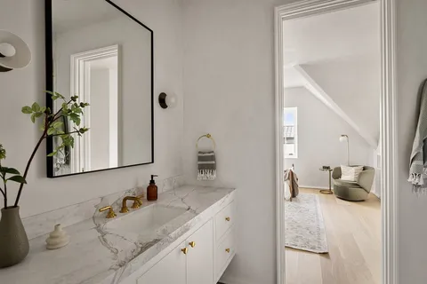 a living room with furniture a window and a potted plant