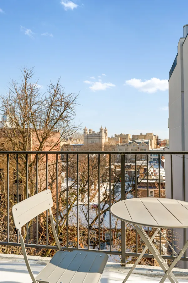 a view of a balcony with chairs and wooden floor