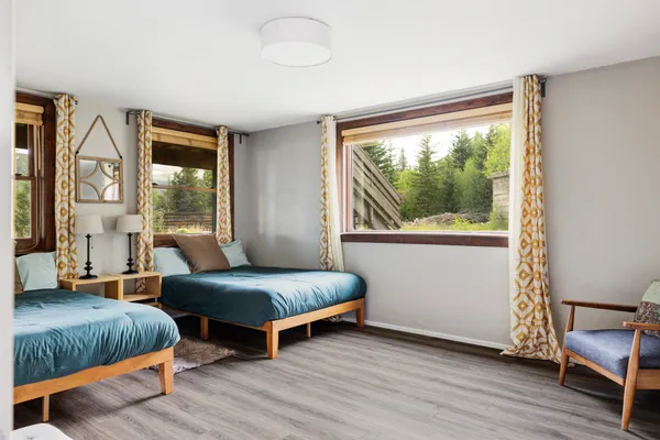 a bedroom with two beds and a large window