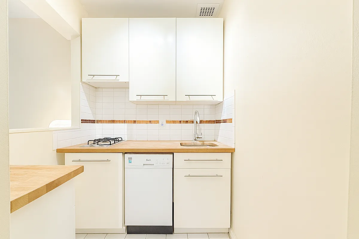 229 East 29th Street, Unit 3A Manhattan, NY 10016 - Photo 5 of 7 a kitchen with a sink cabinets and a window