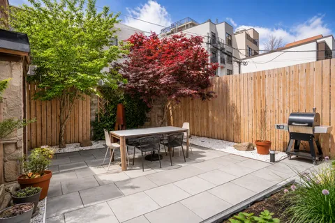 a backyard of a house with table and chairs