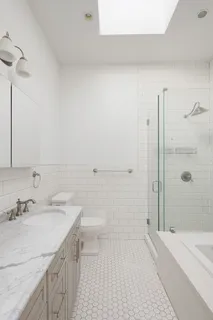 a bathroom with a sink a toilet and shower