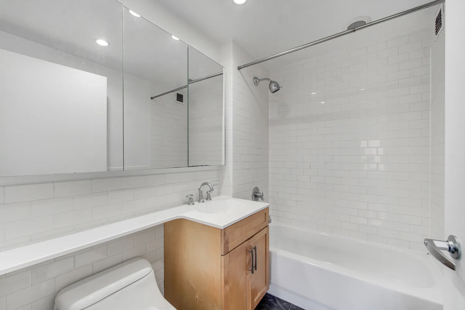 a bathroom with a tub sink vanity and a mirror