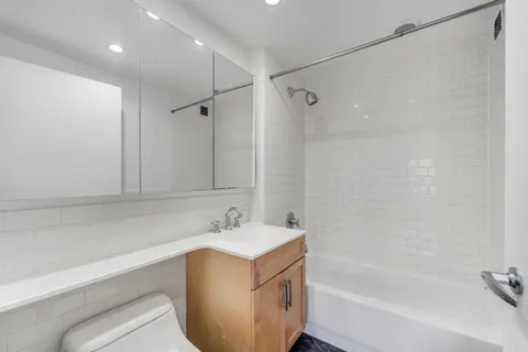 a bathroom with a tub sink vanity and a mirror