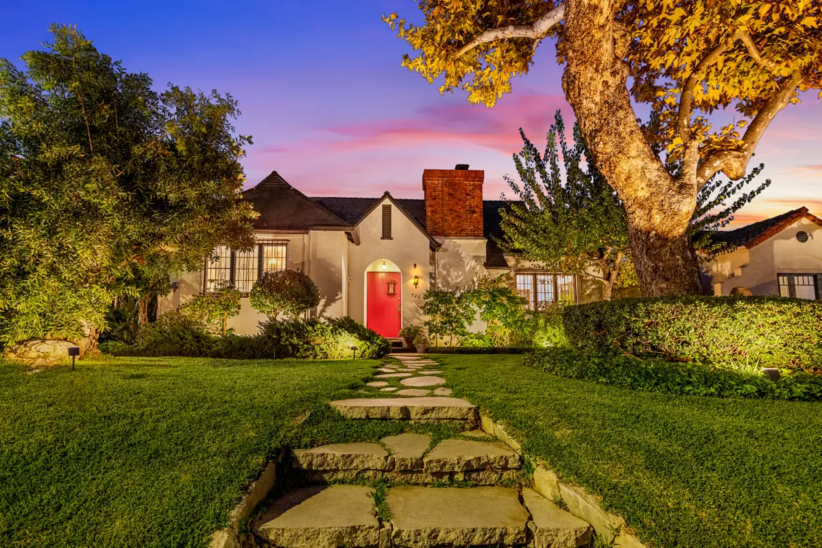 a front view of a house with a yard and potted plants