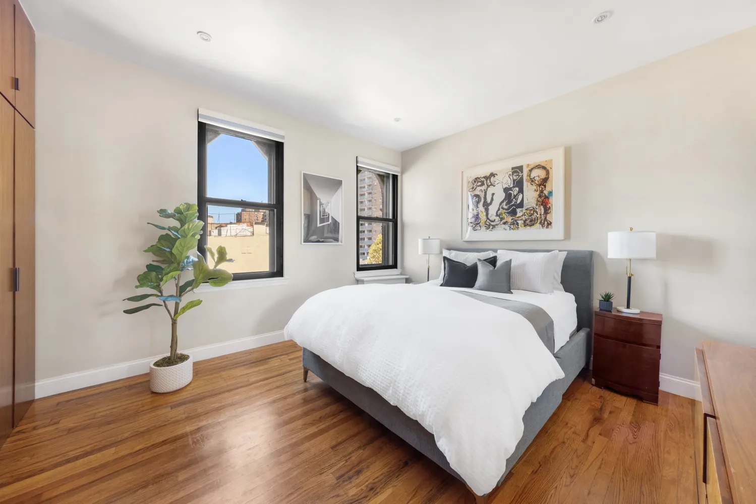 a spacious bedroom with a bed and a potted plant