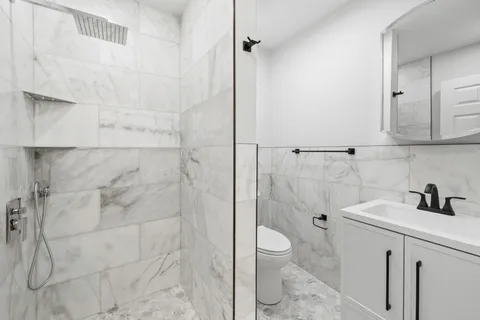 a bathroom with a sink a toilet and shower