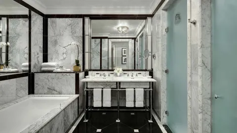 a bathroom with a granite countertop sink a large mirror and a bathtub