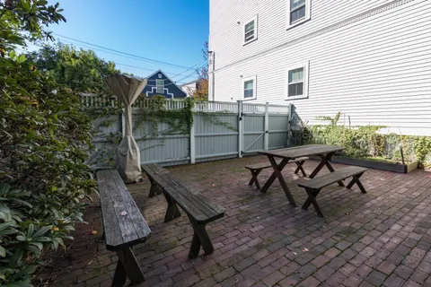 a backyard of a house with table and chairs