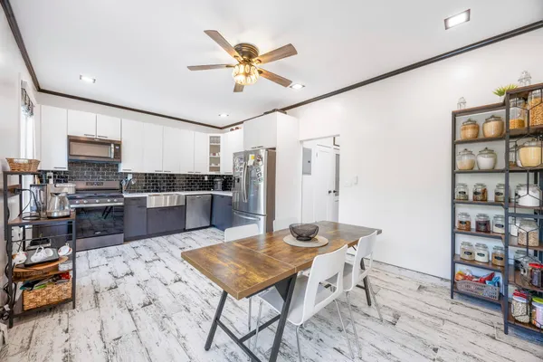 a kitchen with stainless steel appliances kitchen island granite countertop a sink cabinets and wooden floor