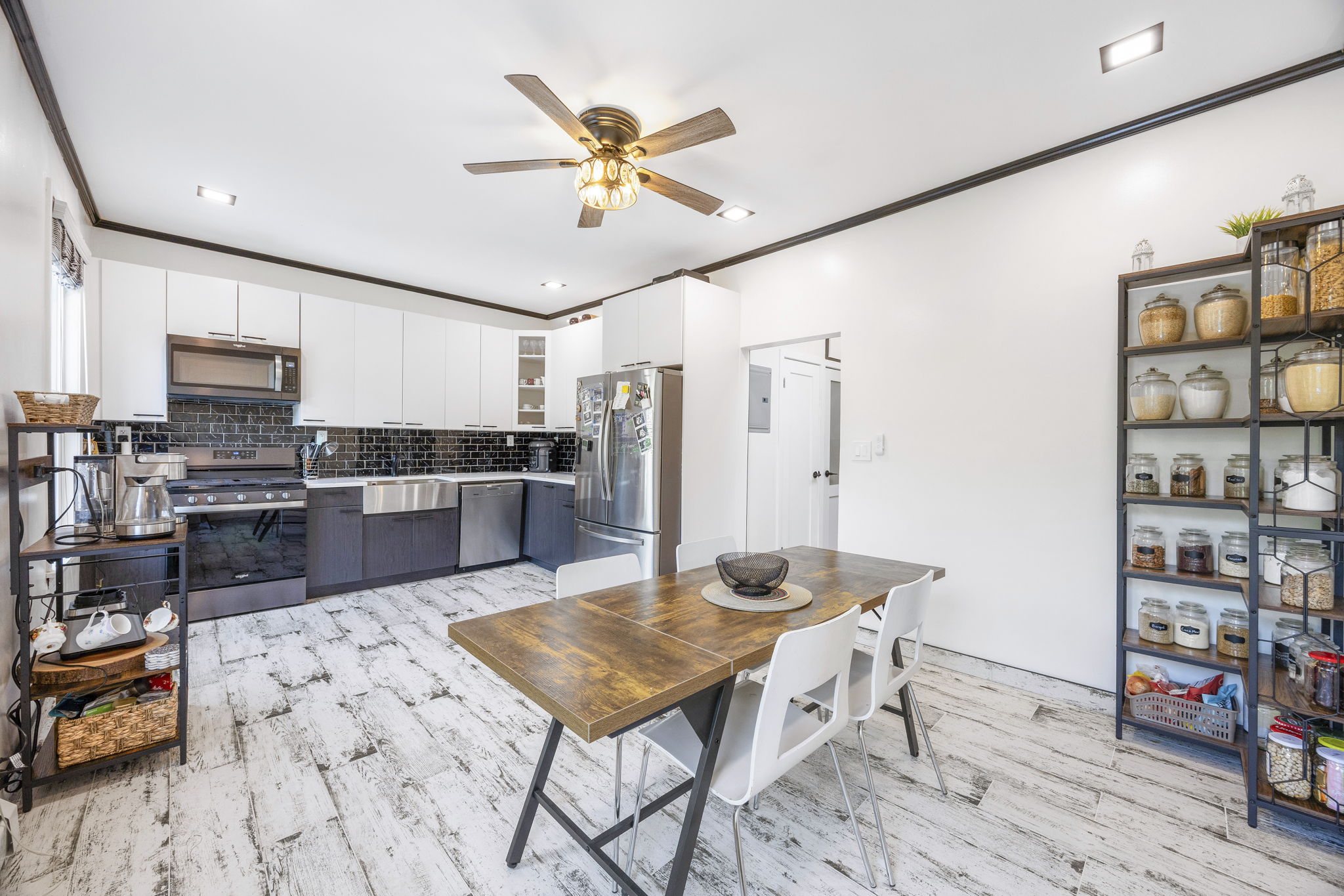 a kitchen with stainless steel appliances kitchen island granite countertop a sink cabinets and wooden floor