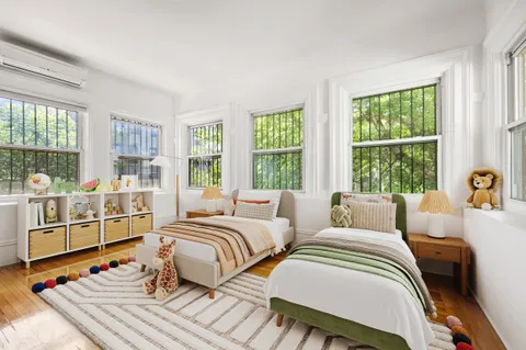 a bedroom with two beds and a large window