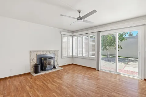 an empty room with fireplace fan and windows