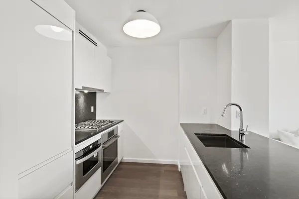 a kitchen with stainless steel appliances granite countertop a sink a stove and a refrigerator