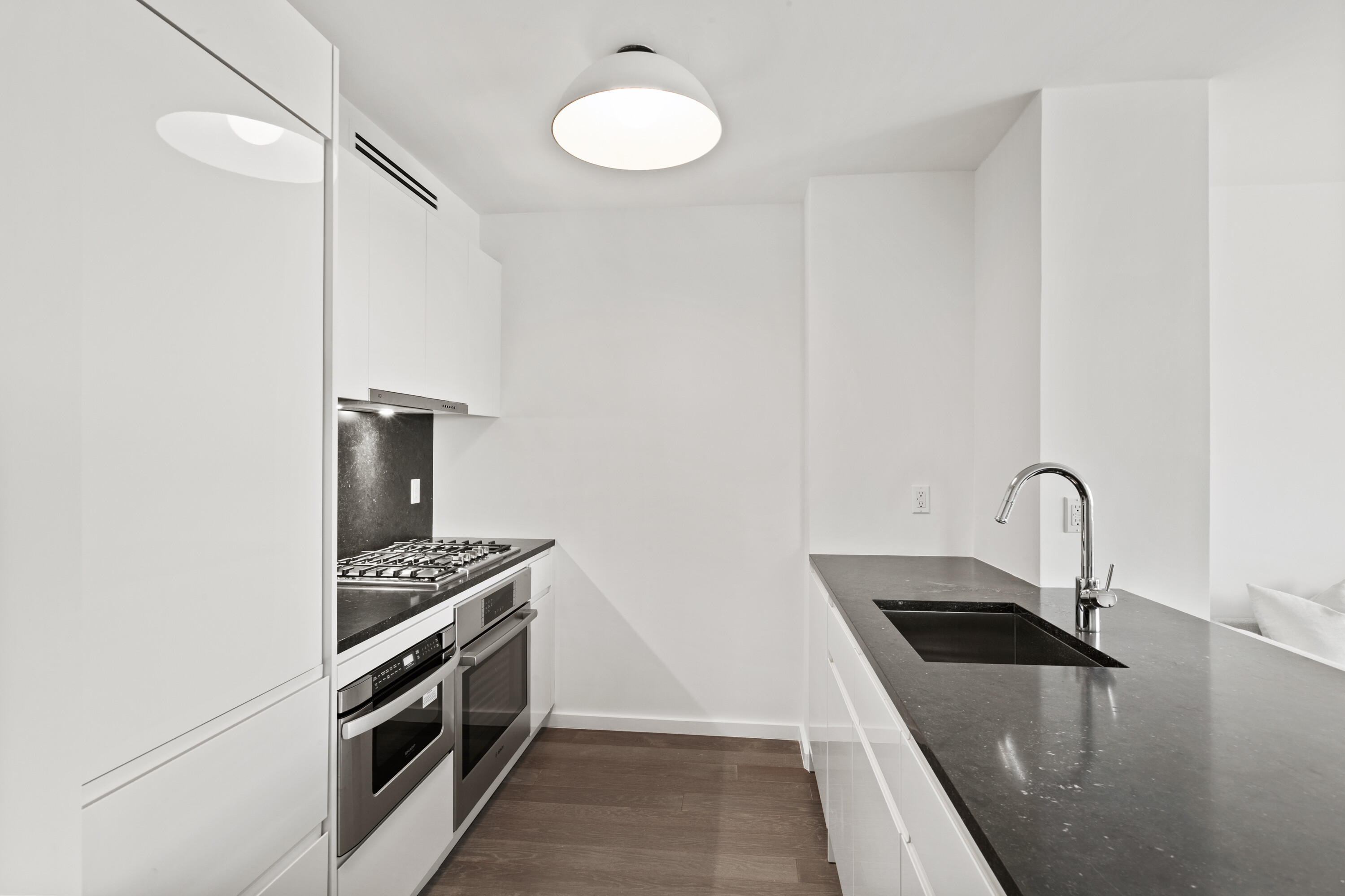 385 1st Avenue, Unit 20B Manhattan, NY 10010 - Photo 2 of 10 a kitchen with stainless steel appliances granite countertop a sink a stove and a refrigerator