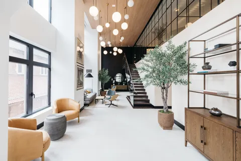 a living room with furniture a chandelier and a large window