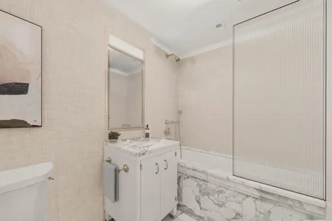 a bathroom with a shower sink vanity and mirror
