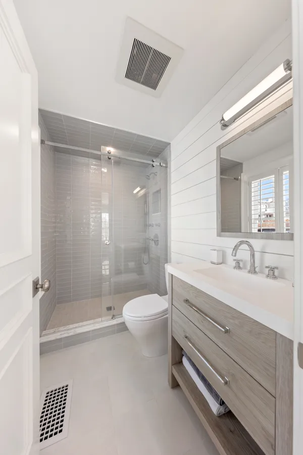 a bathroom with a bathtub shower sink vanity and toilet
